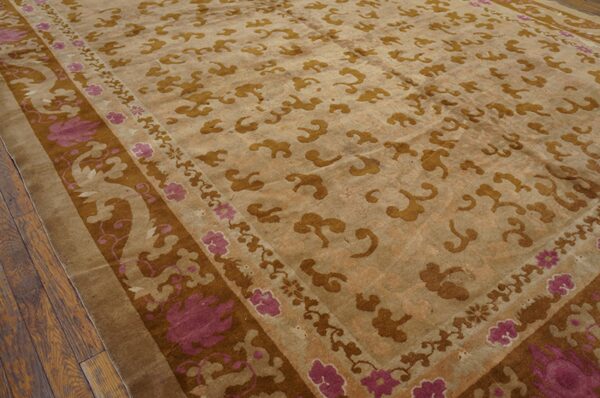 Muted gold cloud motifs cover a tan rug field, accented by a dark brown and magenta floral border.