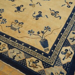 Low-pile rug with tan field, dark blue border, and scattered vases on wood plank flooring.
