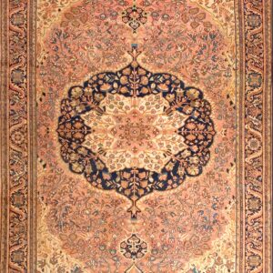 Ornate pink rug featuring a large navy central medallion and detailed floral patterns throughout the field.