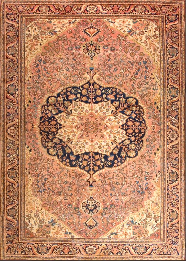 Ornate pink rug featuring a large navy central medallion and detailed floral patterns throughout the field.
