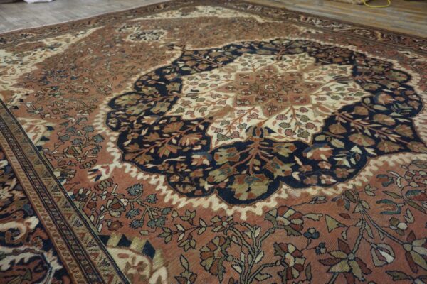 Ornate rug featuring a large navy and cream medallion against a reddish-brown floral field.