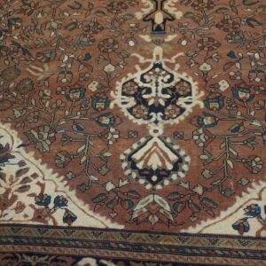 Intricate low-pile rug featuring a rust field, detailed flowering vines, and contrasting ivory and navy medallions.