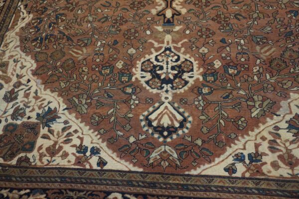 Intricate low-pile rug featuring a rust field, detailed flowering vines, and contrasting ivory and navy medallions.