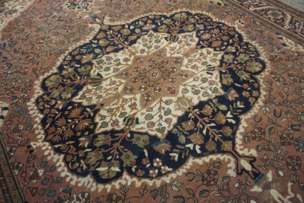 Intricate floral rug featuring a scalloped navy medallion centered on a salmon and cream field.