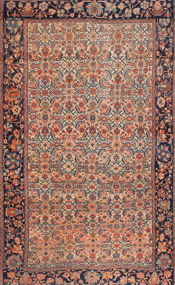 An intricate low-pile rug featuring a cream field, coral and teal motifs, and a wide dark blue floral border.