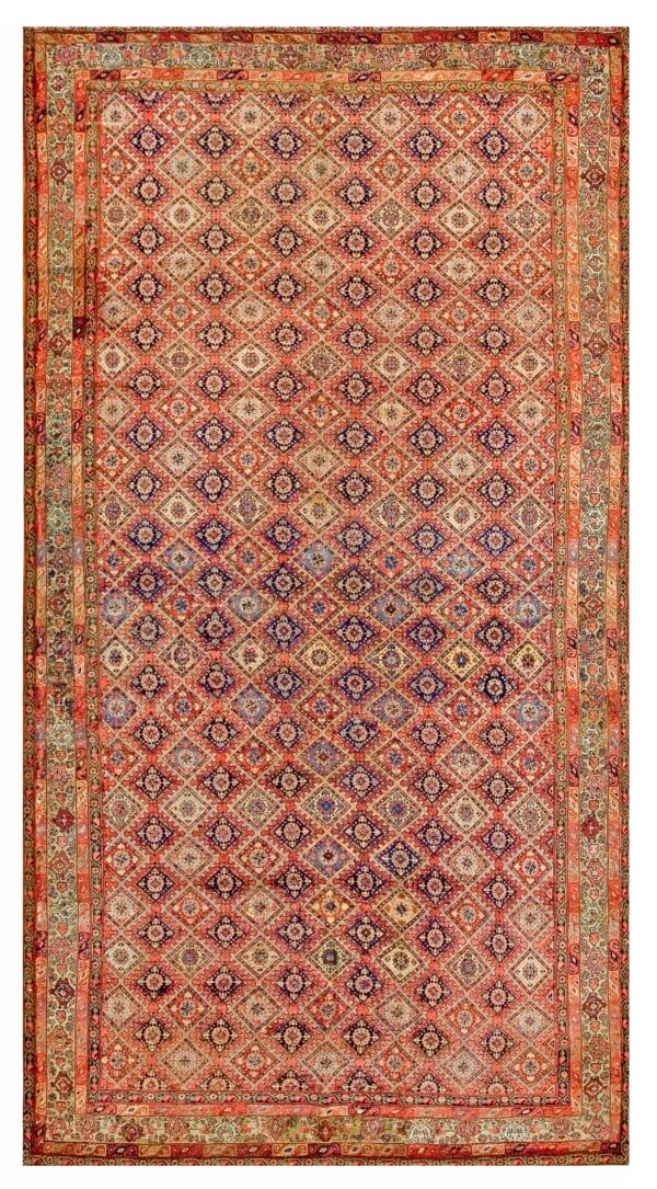 A rectangular rug featuring a dense, repeating diamond pattern in salmon, indigo, cream, and pale green tones.