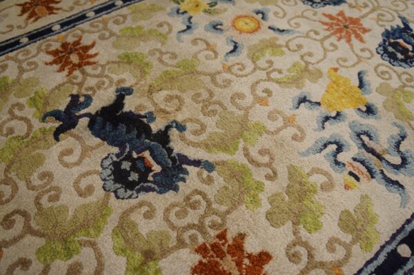 Textured rug featuring a cream background with complex floral designs in blue, rust, yellow, and sage green.