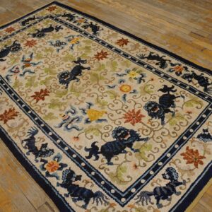 Cream rug with a navy border and stylized blue animal motifs lying on aged hardwood flooring.