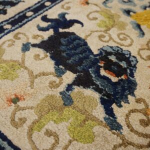 Chunky pile rug detail showing a cream field with dark blue, lime, rust, and yellow floral designs.