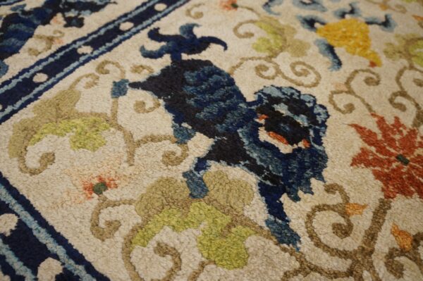 Chunky pile rug detail showing a cream field with dark blue, lime, rust, and yellow floral designs.