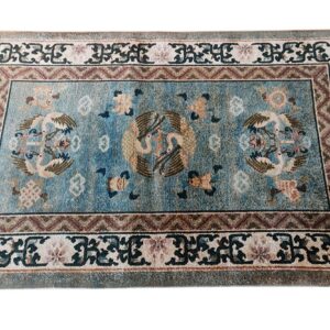 Teal blue rug with an ornate pattern of large stylized birds and complex geometric and floral borders.