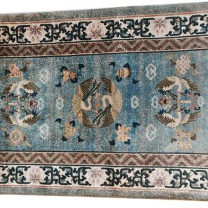 Distressed low-pile rug with a blue field, central bird medallions, and elaborate multi-colored geometric and scrollwork borders.