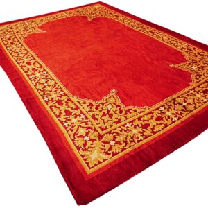 Smooth red rug with a prominent, elaborate golden floral border on all sides.