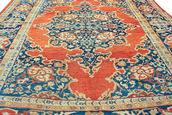 Traditional high-contrast rug showing an orange field with elaborate blue and gold floral patterns.