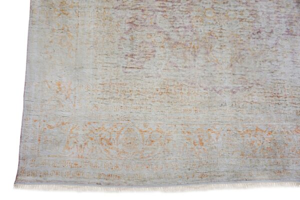 Low-pile rug section showing light gray, faded orange, and purple distressed traditional patterns and fringe.