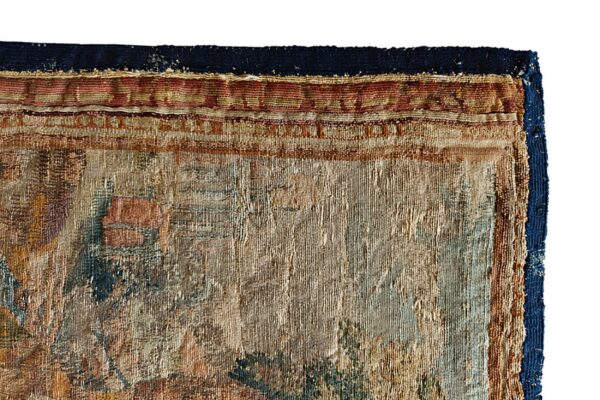 Detail of a textured low-pile rug featuring intricate patterns in beige, brown, rust red, and faded teal.