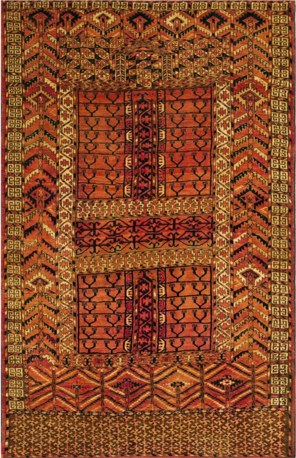 Red and orange rug with dense geometric patterns and stylized black symbols throughout the central field.