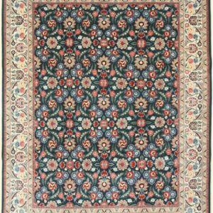 Deep indigo rug with intricate floral patterns in red, pale blue, green, and a wide cream medallion border.