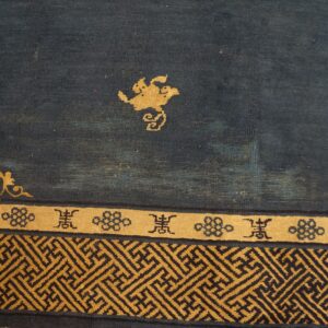 The dark blue rug field has gold floral elements and geometric fretwork borders.