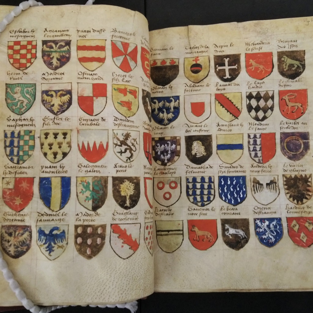 Two pages of an illuminated manuscript show rows of colorful heraldic shields with handwritten descriptions.