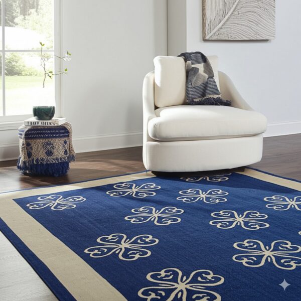 A blue and beige quatrefoil-patterned rug lies on a dark wood floor beneath a cream armchair.
