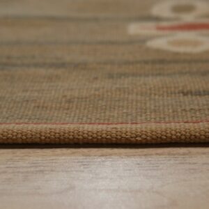 Textured brown woven rug edge with a thin red line rests on light wood grain flooring.