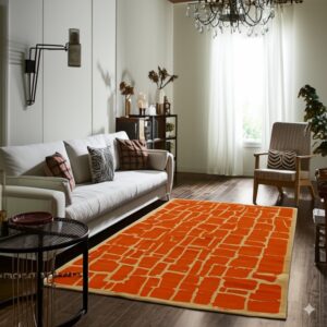 Low pile orange rug patterned with irregular tan rectangular blocks on dark wood floors.