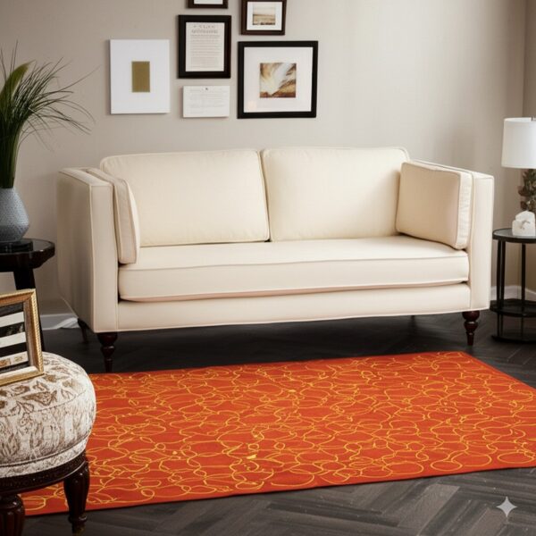 A vibrant orange rug with a gold abstract looping pattern sits under a cream sofa.