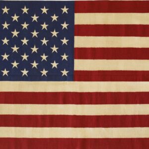 Low-pile rug featuring red and cream stripes and a navy field covered with cream stars.