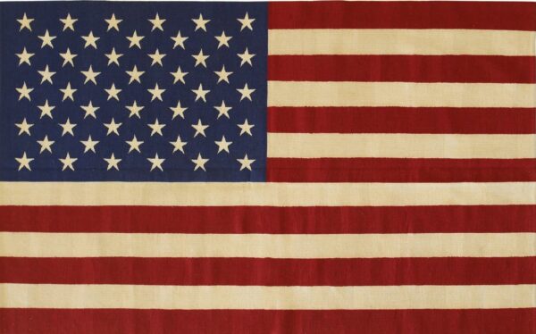 Low-pile rug featuring red and cream stripes and a navy field covered with cream stars.