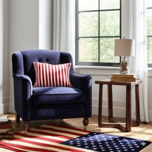 Red, white, and blue rug with a flag pattern sits beneath a navy armchair and dark wood end table.