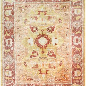 Gold and rust colored traditional rug with a central medallion and contrasting wide borders.