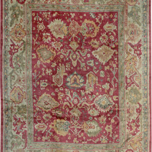 Deep red traditional pile rug featuring botanical motifs in sage, gold, and taupe borders.