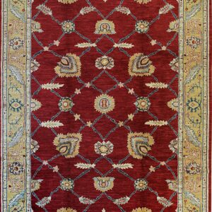 Deep red rug with a golden tan border and a repeating floral trellis pattern in blue and yellow.