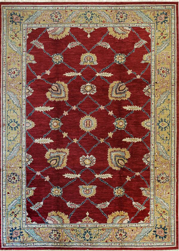 Deep red rug with a golden tan border and a repeating floral trellis pattern in blue and yellow.