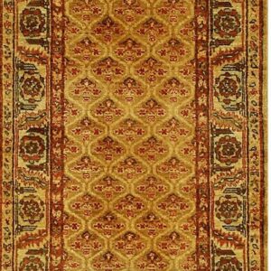 Long runner rug with a gold central field, repeating red pattern, and ornate floral borders.