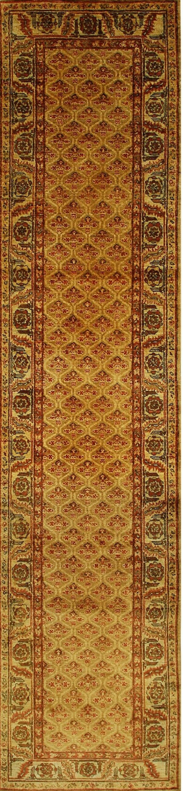 Long runner rug with a gold central field, repeating red pattern, and ornate floral borders.