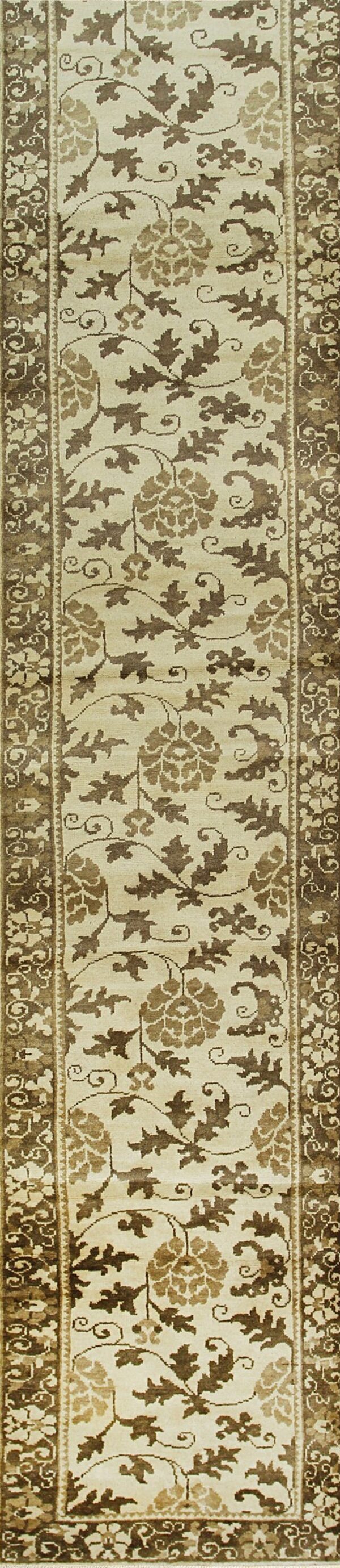 Low-pile runner featuring a cream background with brown floral vines and leaves inside dark, multi-layered borders.