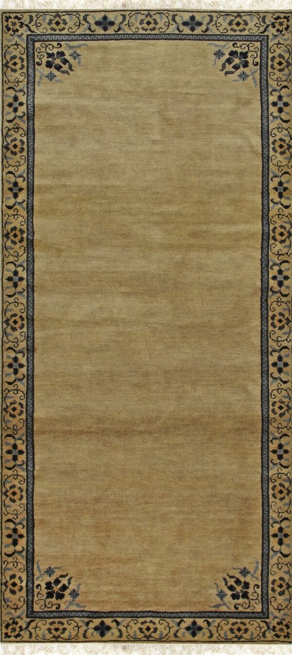 Gold runner rug with a low pile field and an ornate black and blue floral border.