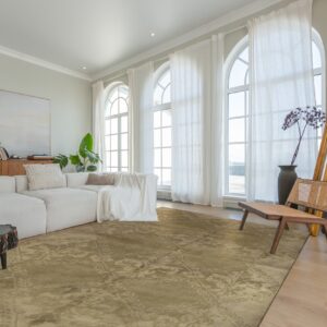 A muted khaki rug with subtle ornate patterns anchors a modern living space with light wood floors.