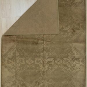 Low-pile olive green rug displaying a tone-on-tone damask pattern, folded over on light wood flooring.