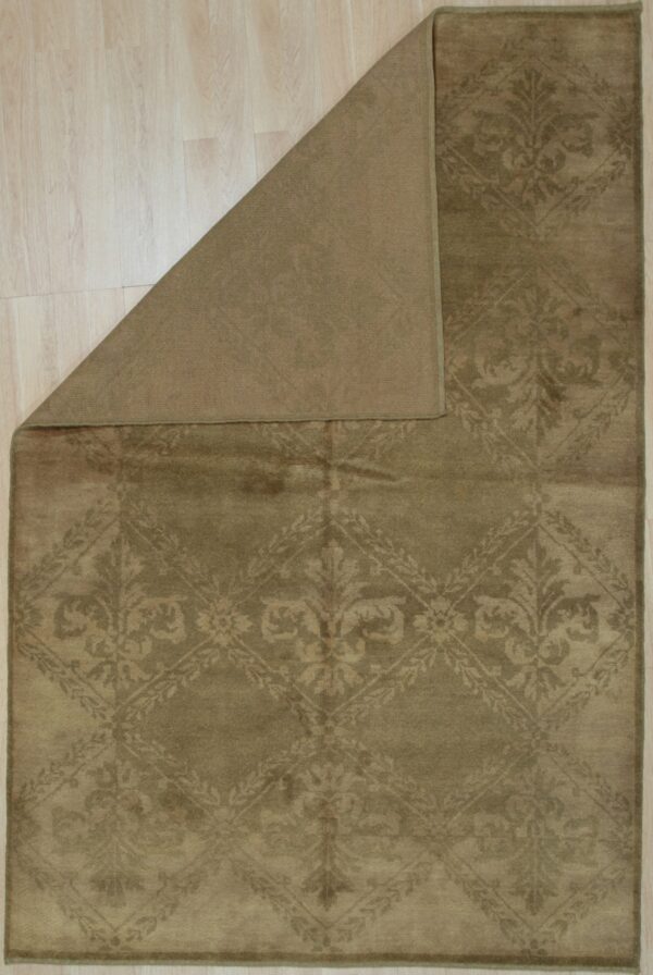 Low-pile olive green rug displaying a tone-on-tone damask pattern, folded over on light wood flooring.