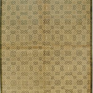 Low-pile rug with interlocking geometric patterns in tan, olive green, and dark brown hues.
