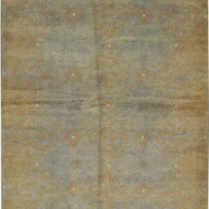 Low-pile rug featuring a faded gold pattern on blue-gray with a tan border and fringes.