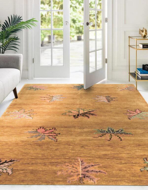 Ochre low pile rug with stylized pink and green leaf pattern near a gray sofa and open white doors.