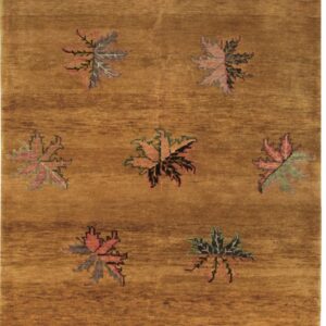 Ochre rug with subtle horizontal abrash and large multicolored, stylized scattered leaf motifs.