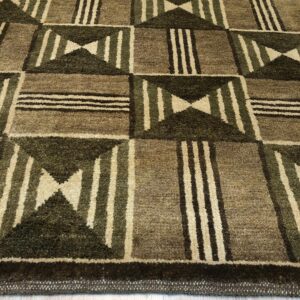 Textured brown and dark green geometric rug with stripes and hourglass patterns rests on light wood planks.