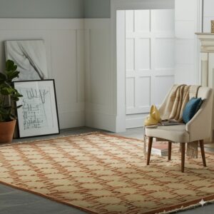 Cream rug with a scribble-like terracotta diamond pattern anchors a bright sitting area with an upholstered chair.