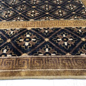 Black and brown geometric rug featuring diamond patterns and a wide golden Greek key border.