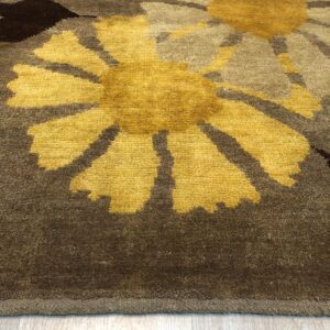 Textured yellow and brown high-pile rug with stylized flowers rests on light wood plank flooring.